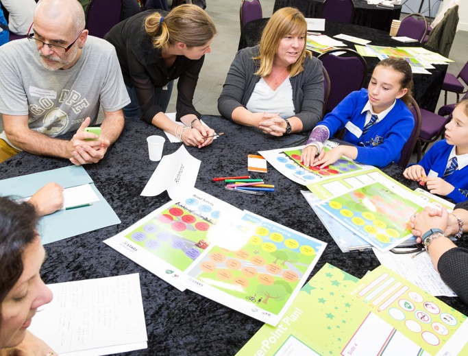 Adults and young people around a table in a working group